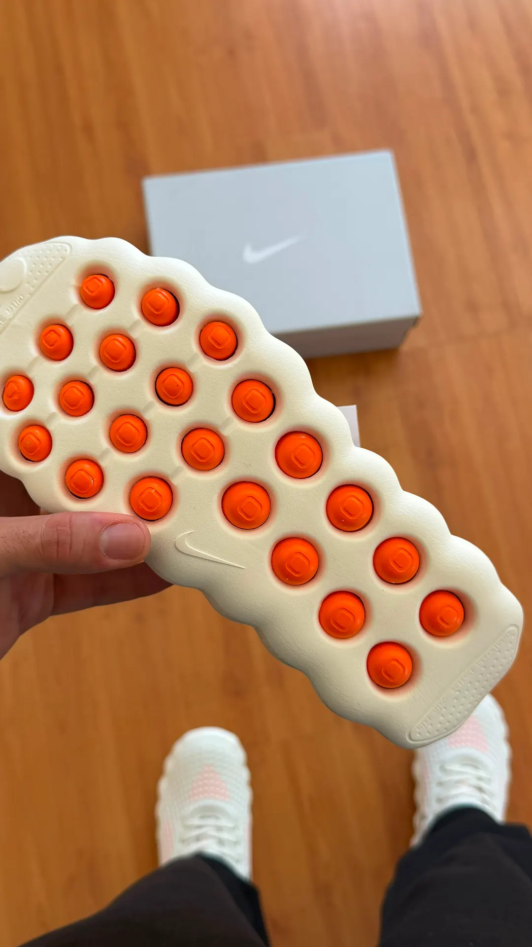 Tênis creme com detalhes perfurados em coral e solado texturizado