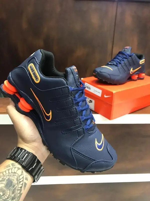 Tênis casual azul-marinho com detalhes em laranja e amortecedores no calcanhar