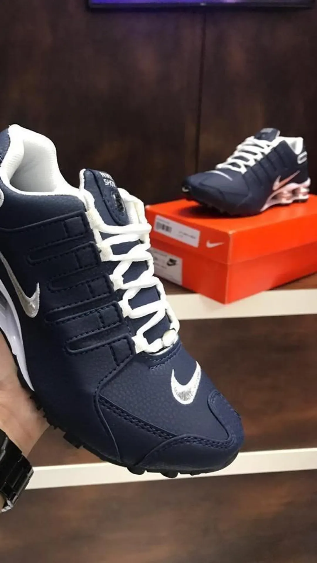Tênis casual azul-marinho com detalhes em laranja e amortecedores no calcanhar