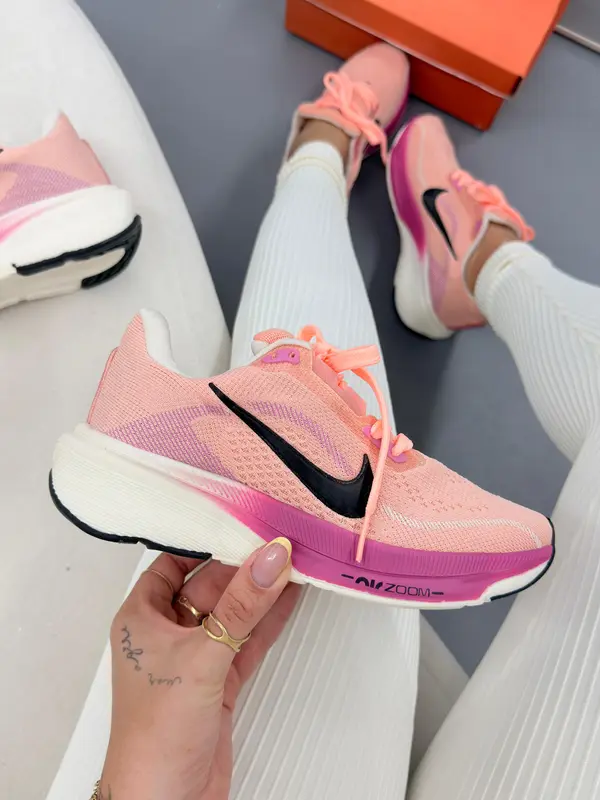 Tênis de corrida rosa claro com entressola branca e detalhes em pink