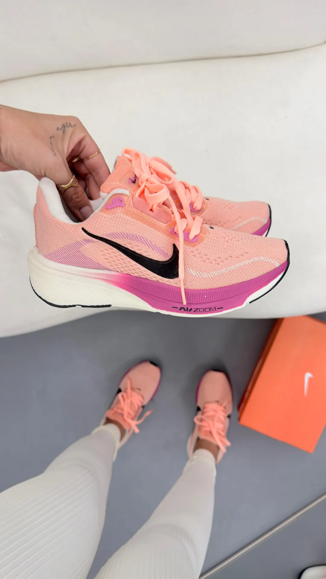 Tênis de corrida rosa claro com entressola branca e detalhes em pink