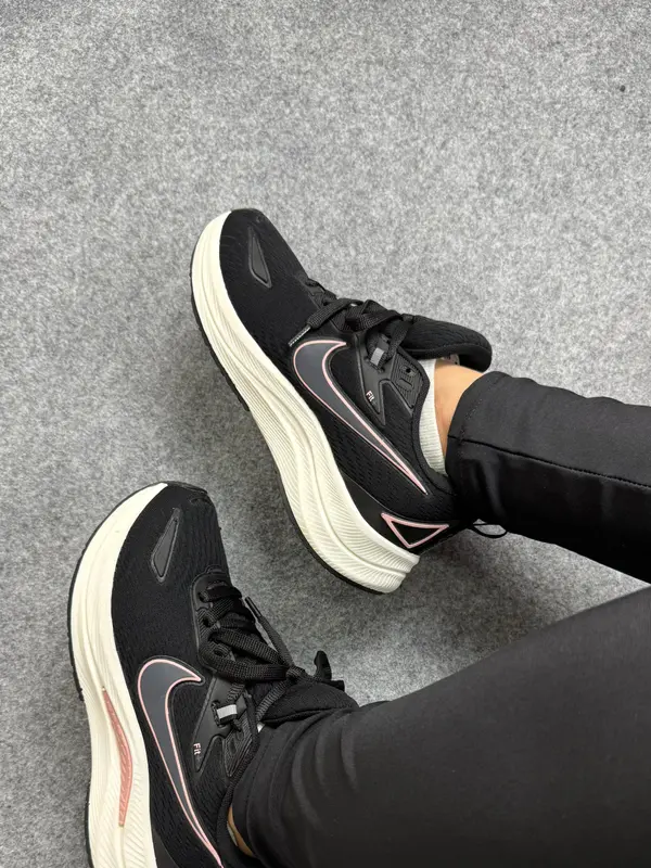 Tênis de corrida preto com detalhes em rosa e entressola off-white