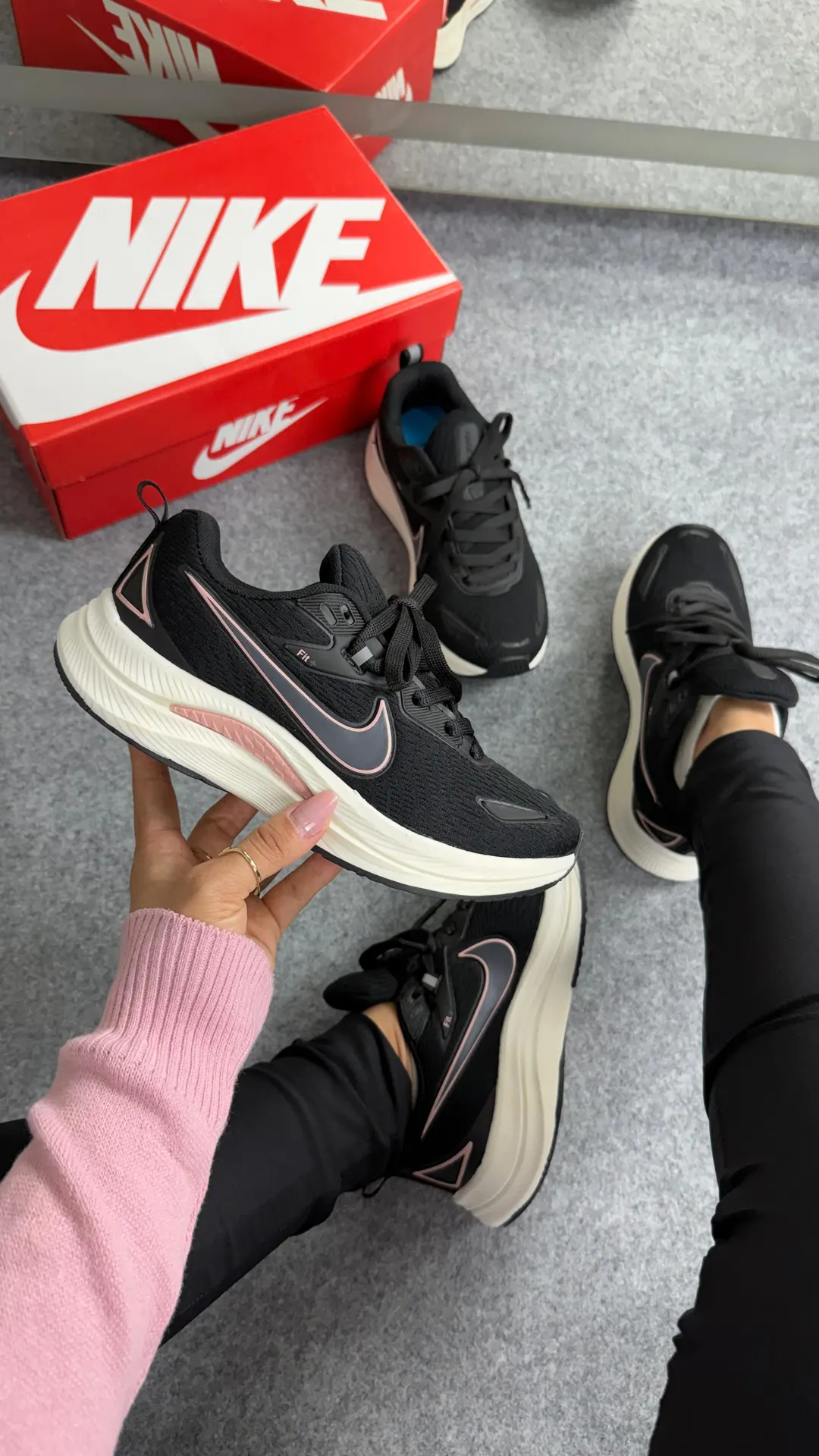 Tênis de corrida preto com detalhes em rosa e entressola off-white