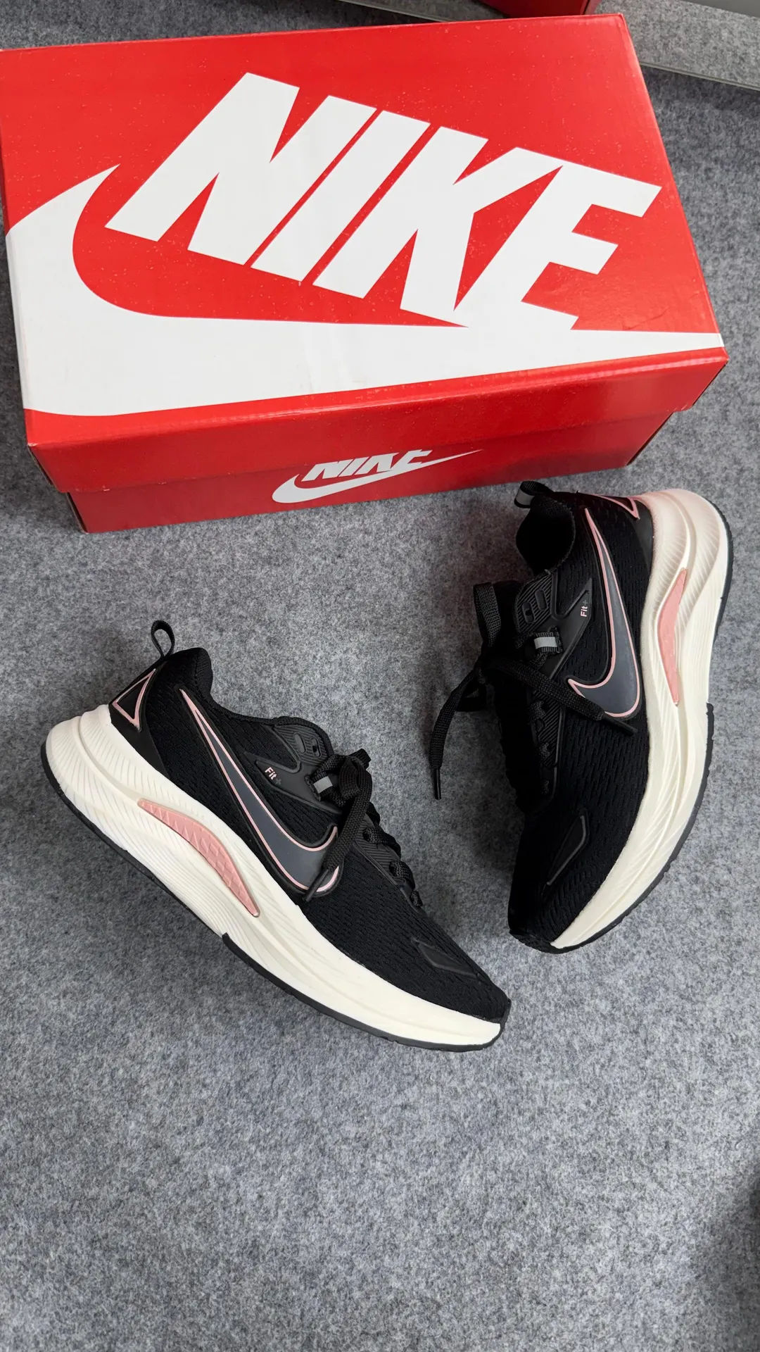 Tênis de corrida preto com detalhes em rosa e entressola off-white