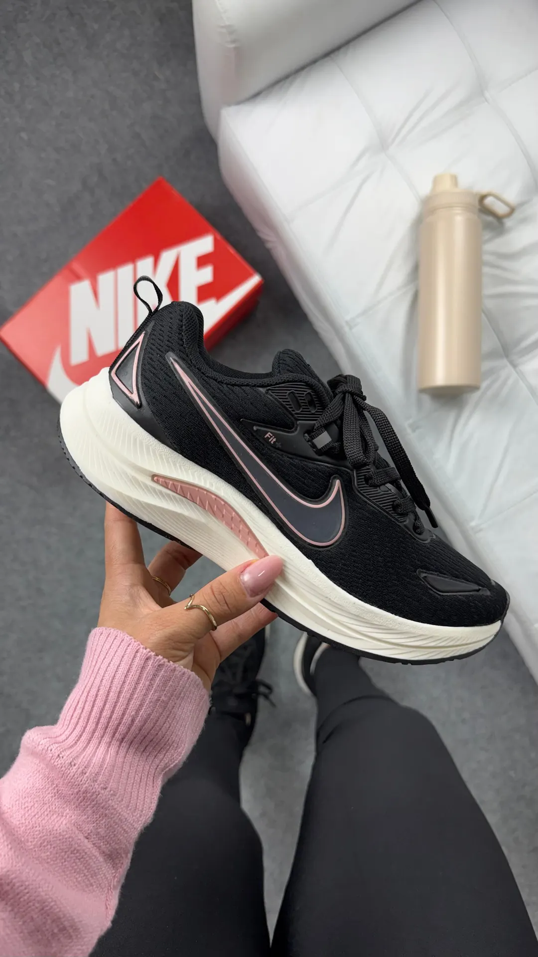 Tênis de corrida preto com detalhes em rosa e entressola off-white