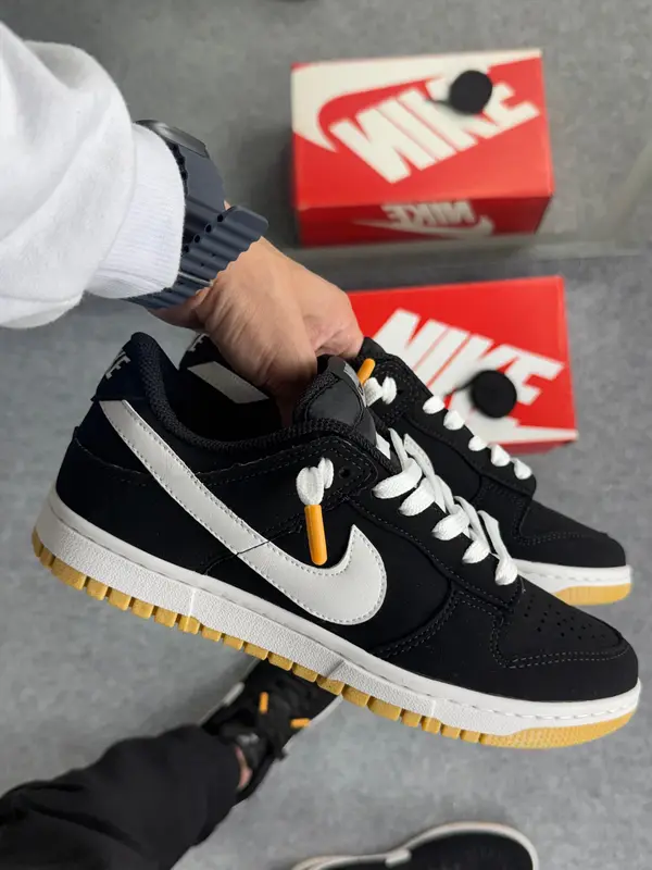 Tênis casual cano baixo preto com logo branco e solado caramelo