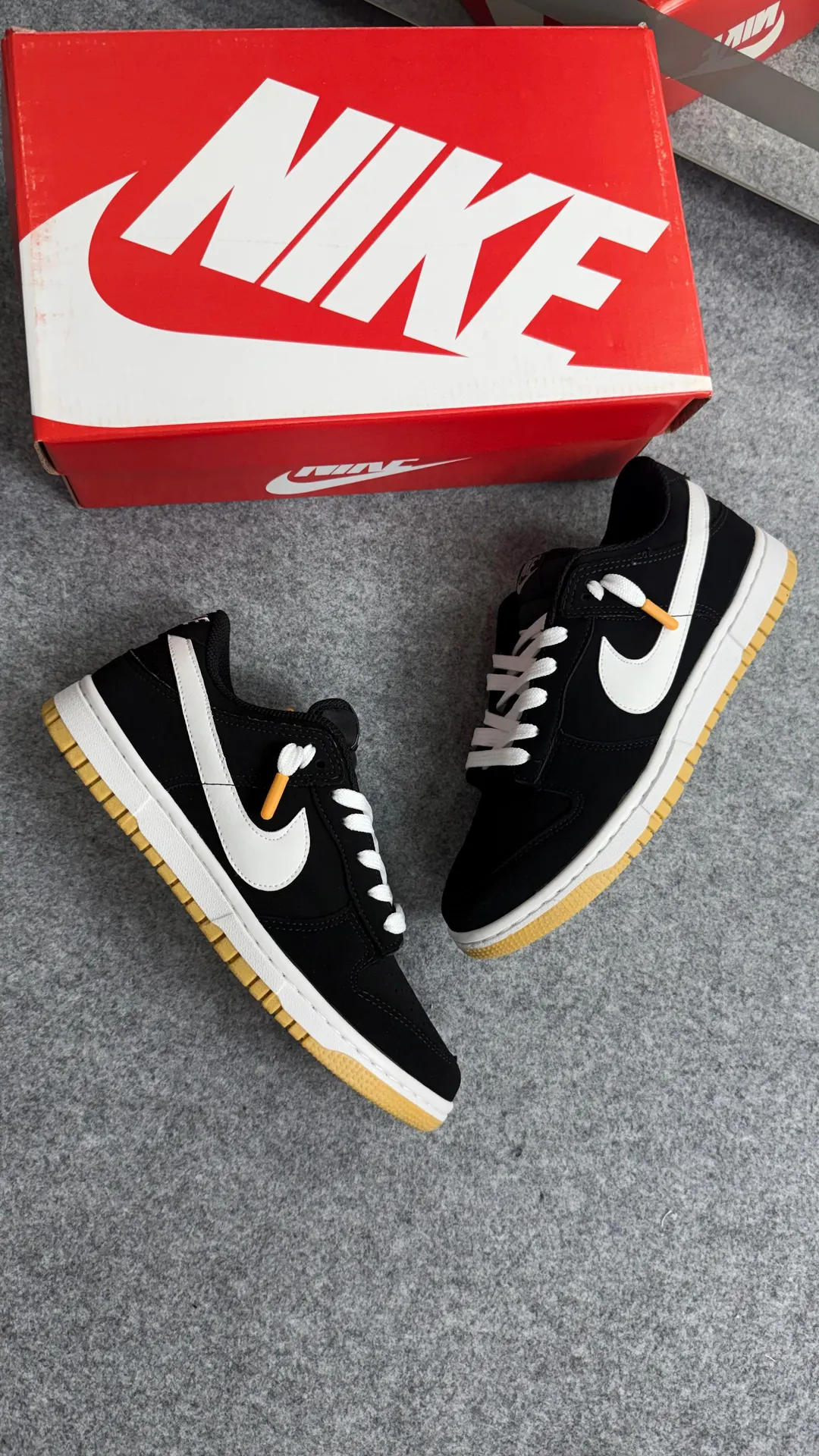 Tênis casual cano baixo preto com logo branco e solado caramelo